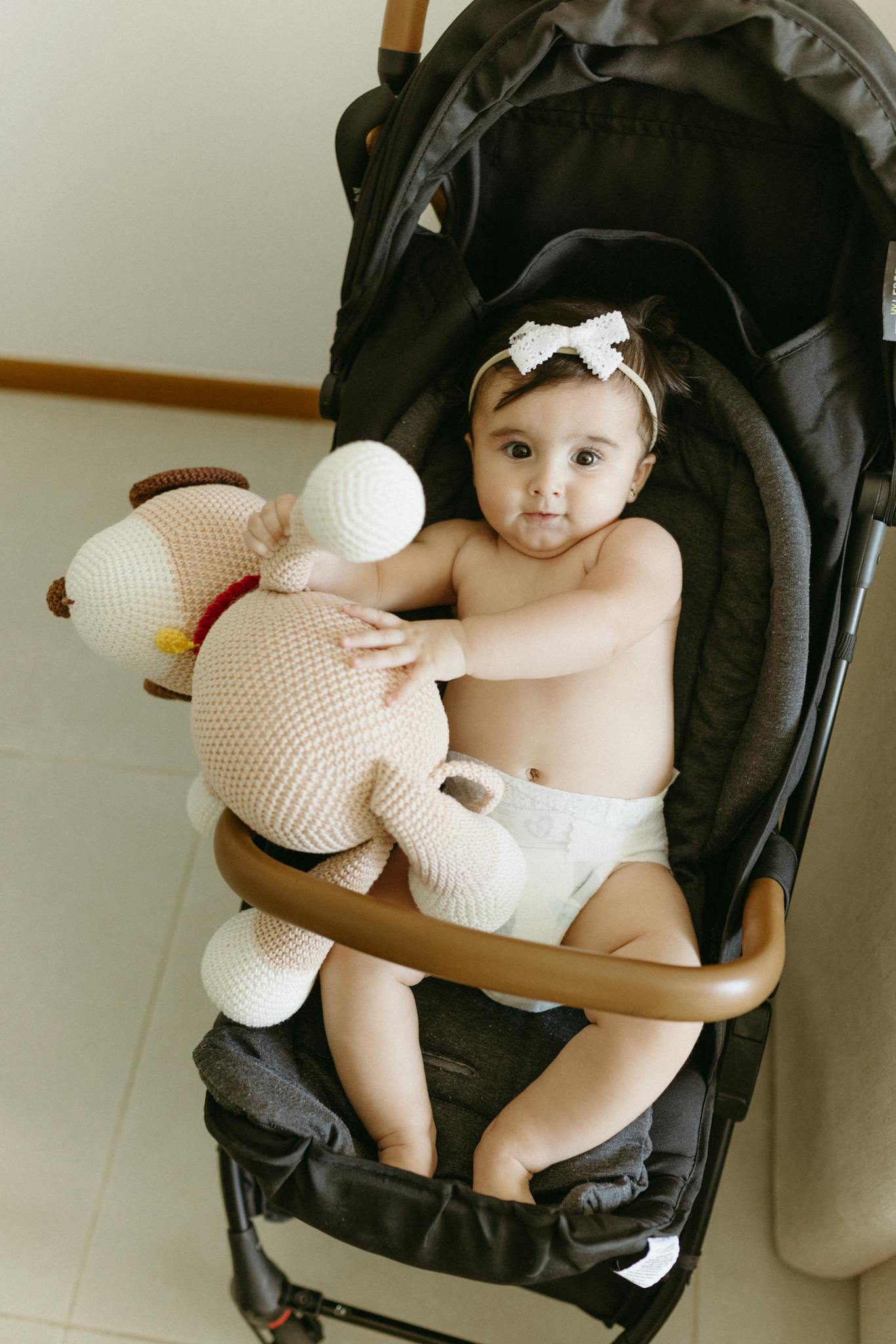 Adorable Baby Girl Sitting In Stroller Holding Adorable baby girl sitting in stroller holding